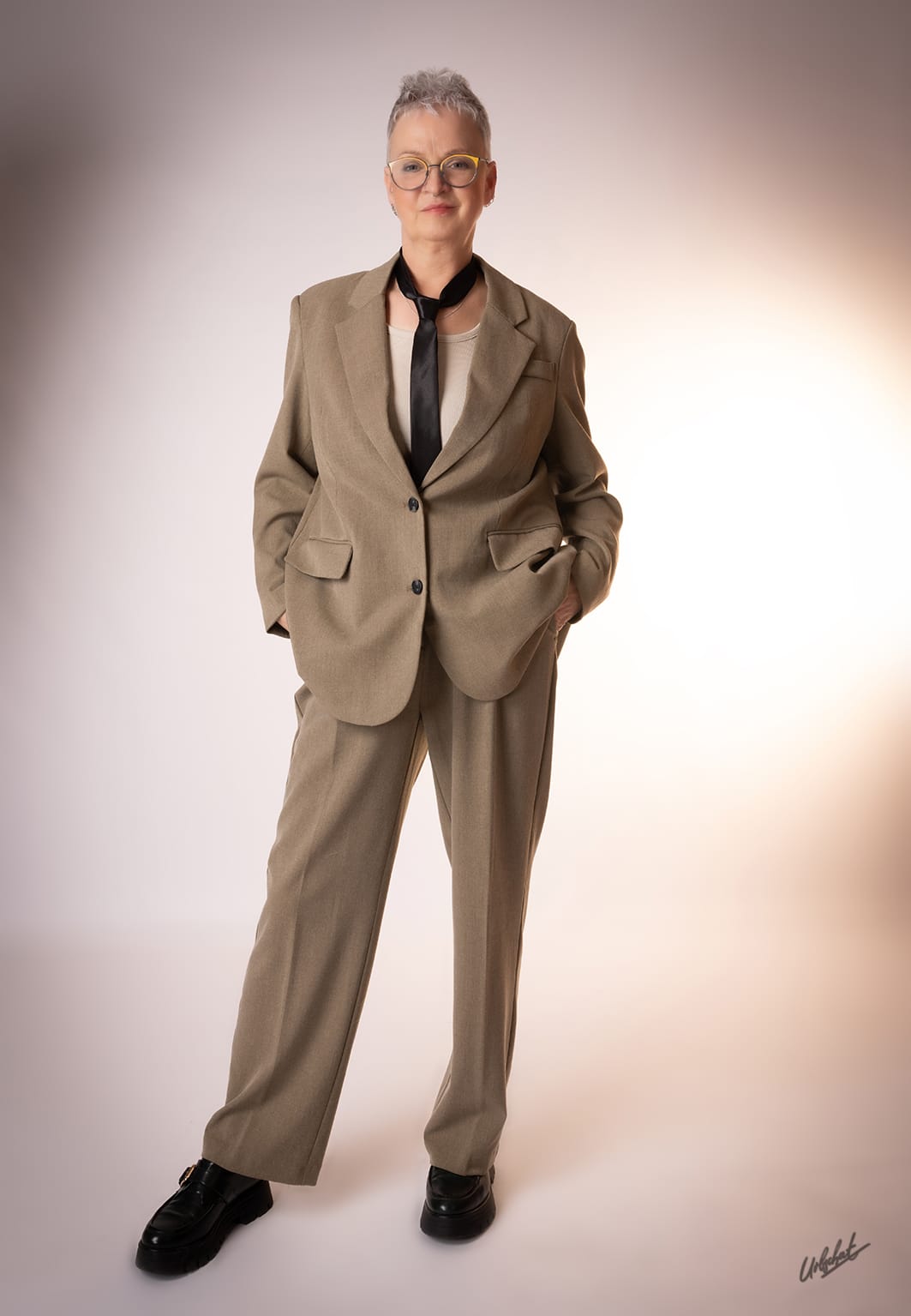 Katlui — Editorial look — beige power suit with yellow-framed cat-eye glasses